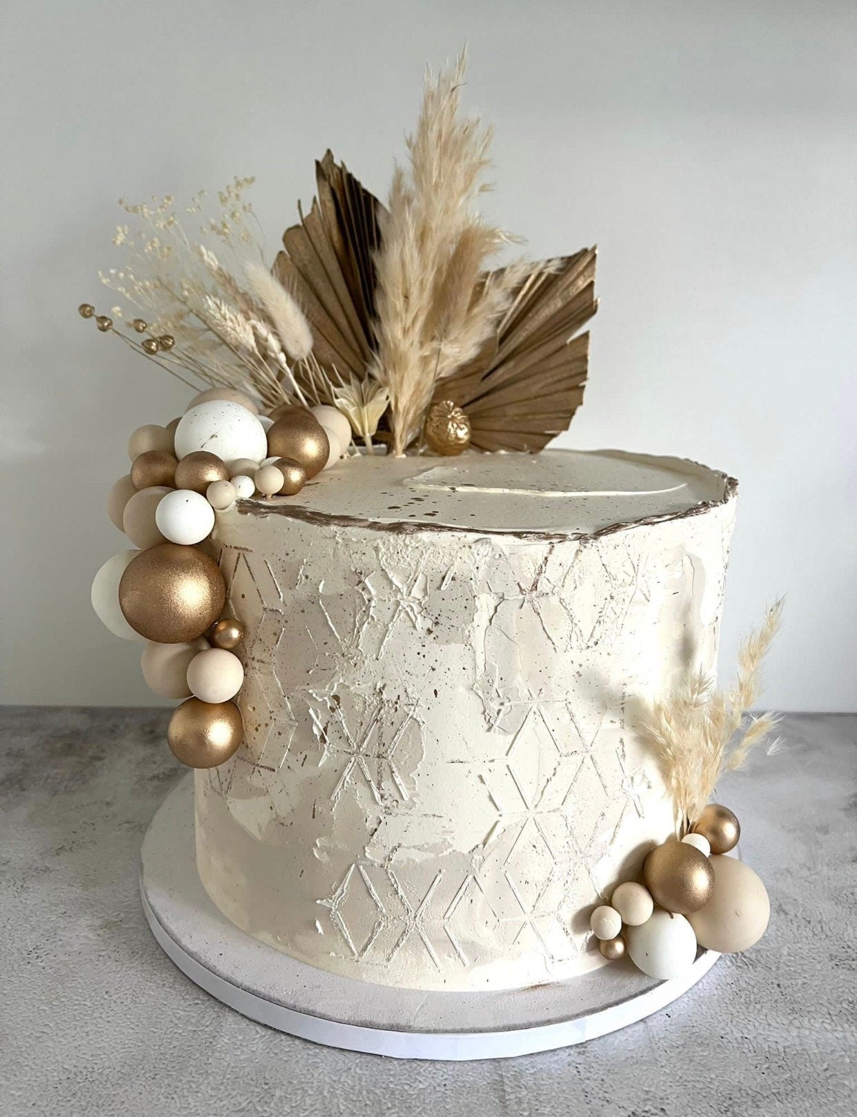 Tortentopper oder Trockenblumenstrauß mit in Weiß und Gold mit zwei Palmblättern, Hafer, Weizen, Lagurus, Craspedia, Phalaris